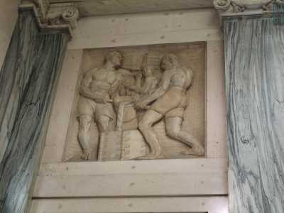...nei pressi di due delle porte notiamo ad esempio una scena con tre uomini in una fonderia...
